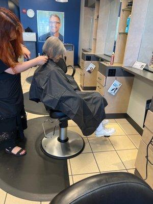 Client in the chair getting hair cut trim