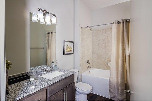 Baths feature modern lighting and granite or marble countertops