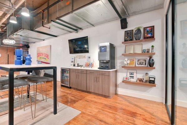 Vintage lounge area with decorative walls, a TV, coffee maker, and mini fridge at South Side on Lamar