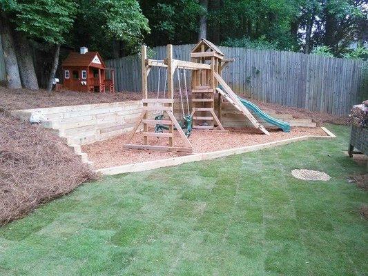 New backyard with play set assembled. New sod, retaining wall