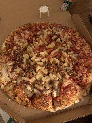 A bbq chicken pizza with mushrooms, tomatoes, and pineapple