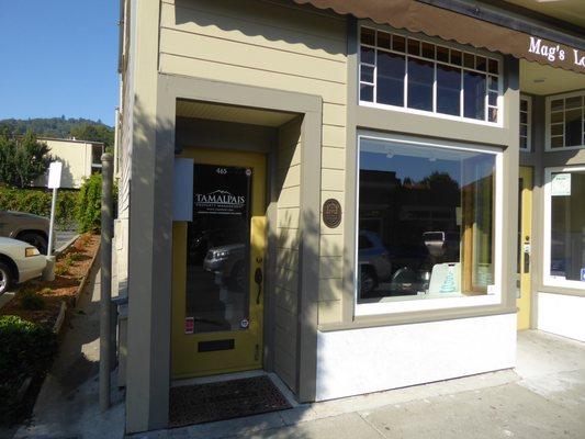 Office entrance door directly on sidewalk to left of Mag's Local Yogurt