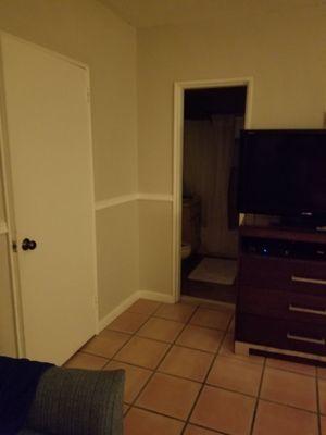 Bathroom (open door), closet on the left and TV in living room