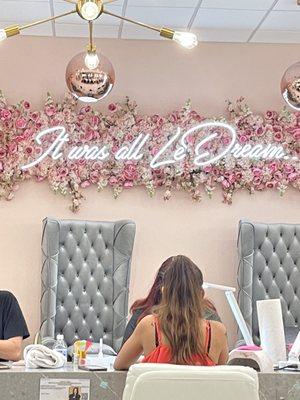 Feature wall above tufted pedi chairs.