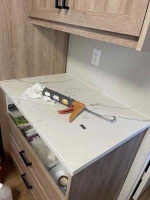 Caulked seams to match your material- white along the wall, clear along the side cabinet panel.