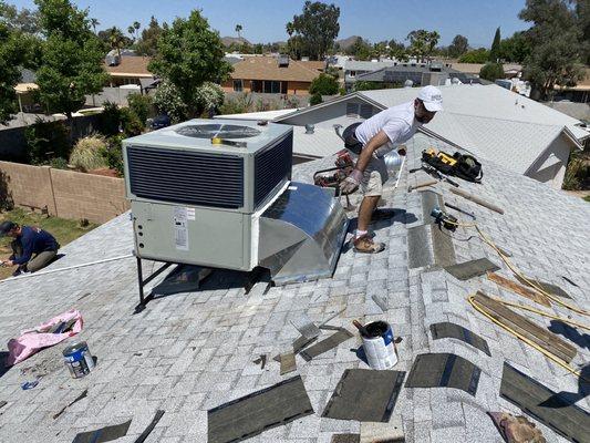 Roofer repairing around where old unit was located.