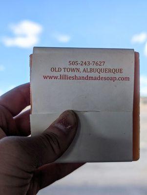 The back of Lillie's Handmade Soaps' bar soap, which bears the shop's contact info, ft. NM scenery & cornflower sky in the background