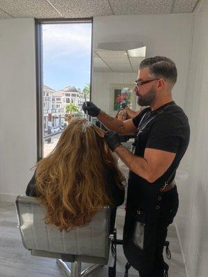 Dariel Saiz, the owner applying a root color touch up.