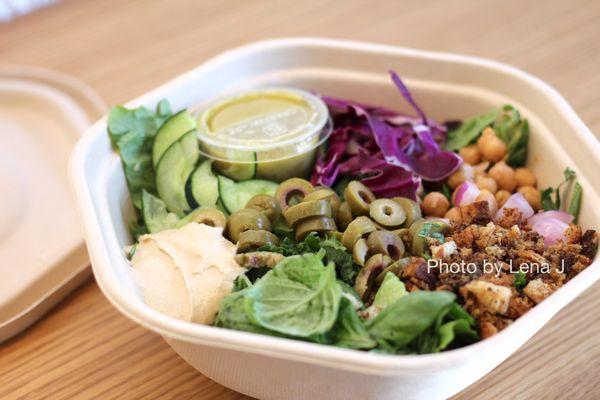 Hummus Crunch Salad - Hummus, olives, chickpeas, tomatoes, cucumbers, cabbage, red onions, basil, za'atar breadcrumbs, pesto vinaigrette