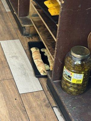 They seem to be storing food on the floor as they walk by the food helping costumers.