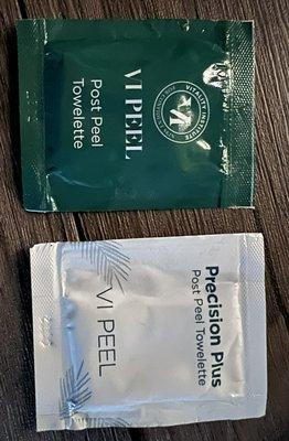 a green and a white towelette side by side with slightly different font and graphic choices, but the same wording "post peel towelette"