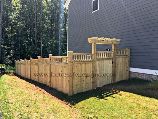 Custom stockade deluxe with deck rail topper and arbor - stepped to flow with the slope of the land. Installed by Fortress Fencing LLC.