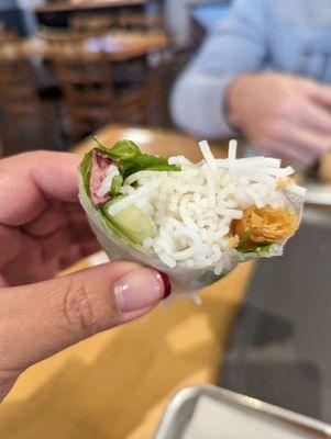 Center of the sausage roll with rice noodles, crispy wrafer, cucumber, herbs and nam.