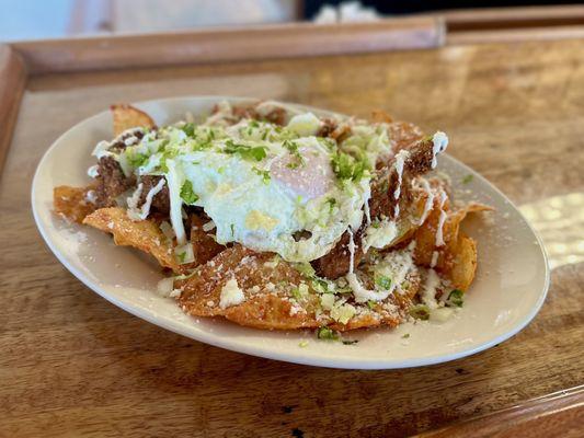 Chilaciles: breakfast style nachos w/ crispy chicken and over easy egg