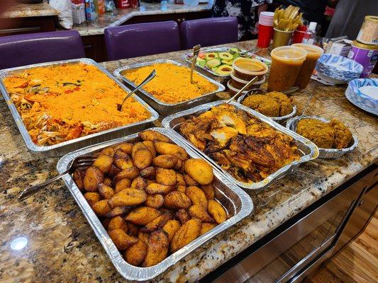 A feast of seafood paella, plantains, chicken, rice, beans, mofungo, sauce for the mofungo, and salad