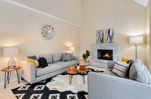 Staged living room in grey and black with yellow accents.