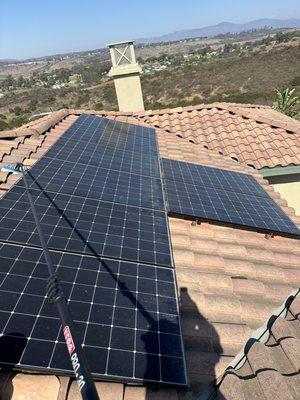 Cleaning Solar Panels on a roof by camp Pendleton in Oceanside