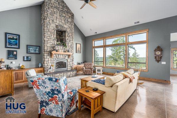 Custom Home Living Room with giant fireplace, vaulted ceilings, radiant heated concrete floors, custom cabinetry, & abundant natural light