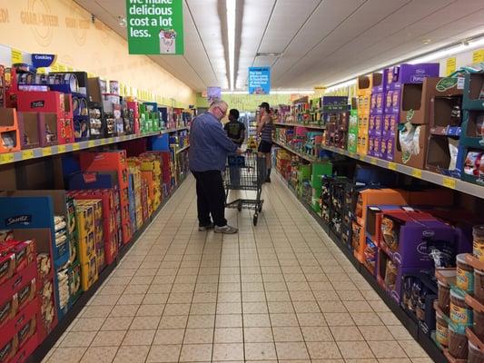 Aldi- food displayed in boxes, rent a cart, bring your own bags. All cuts down on the cost to you.