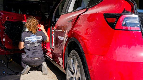 Disassembling a Tesla! She's carefully inspecting and cataloging every part removed and noting areas that may need our attention later.