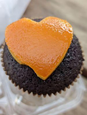 Ube cupcake with leche flan heart on top. Looks as of a little part came off before it was packed.