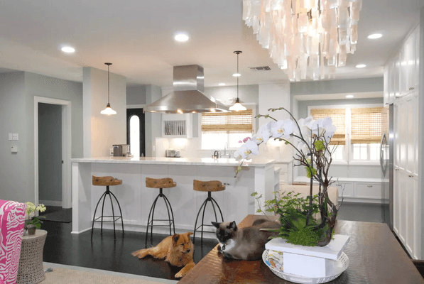 Drop down lighting adds charm to the white-washed peninsula. A stainless steel sink and appliances create a clean look.