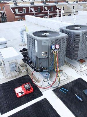 Performing HVAC maintenance on an outdoor unit.