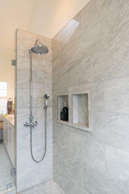 Grey marble porcelain tile shower with marble penny rounds for shower pan. Costa Mesa