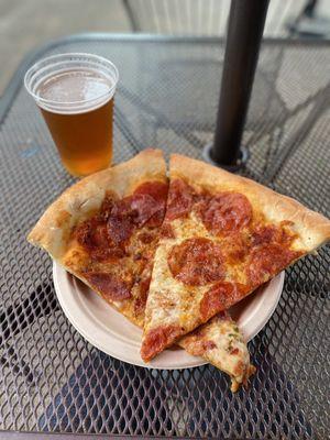 A slice of meat pizza, a slice of pepperoni pizza, and a Buoy beer!