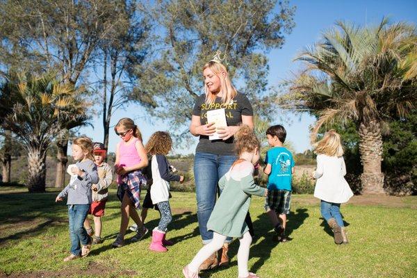 Owner Hilary playing an educational game during one of her kid's bee presentations.