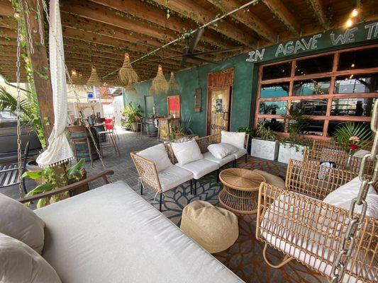 A little living room, waiting area with 2 swings, garage door that opens, and further in the picture are high top tables