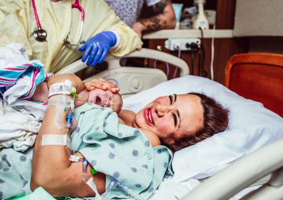 Brand new first time mom smiles as she meets and holds her newborn baby boy for the first time at Baptist Boca Raton Regional Hospital