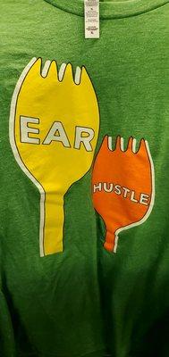 Funny shirt! It says, "Ear Hustle" with two forks, one yellow, one orange.