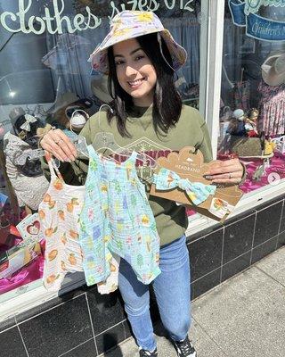 Erika is holding some of our rompers with matching headbands.