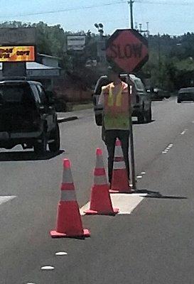 Whats wrong here? 1. The flagger dont have a hard hat on 2. Cones are not recommended around a Flagger at any time.