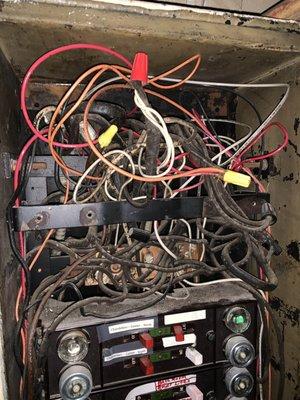 A crowded electrical panel with outdated cloth wiring.