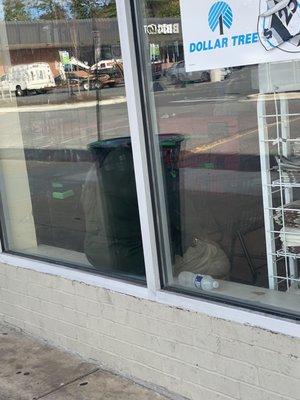 The cashier sitting on windowsill instead of working. She left the only other cashier to handle customers