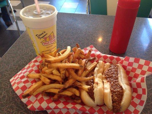 Two beautiful Hot Dogs with Chili and Mustard, French Fries, and a Soda