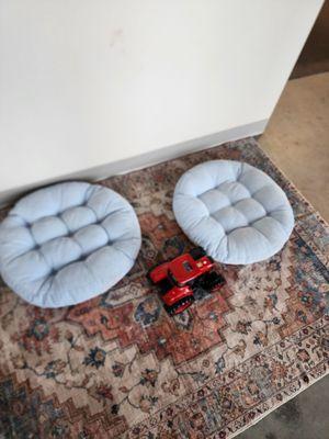 Floor pillows and vehicle on rug for play