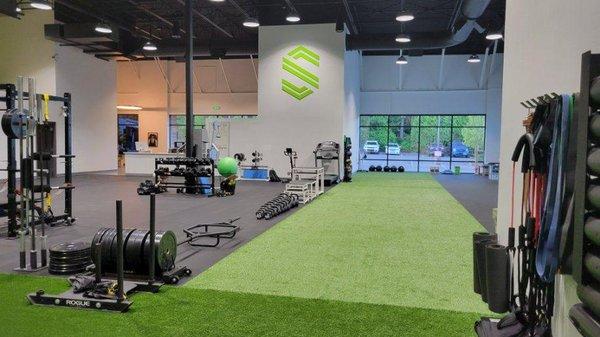 PRO SPORT Gig Harbor clinic's gym, Physical Therapy, Chiropractic, Astro turf, racks/weights, kettlebells, PRO SPORT insignia on wall