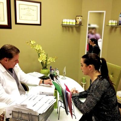 Our own Dr. George Herrera consults with a patient on her treatments