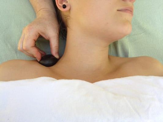 Massage with warm stones in the neck area