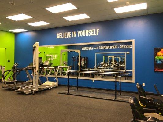 Treadmills and parallel bars on the interior of the gym.