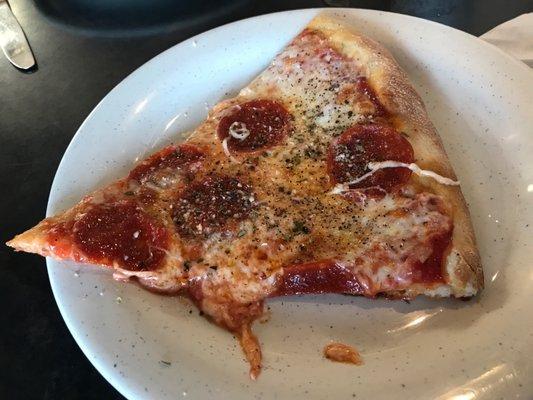 A slice with oregano, pepper and parmesan cheese.