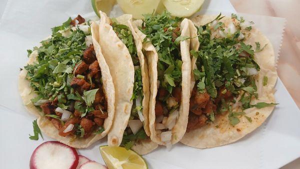 Tacos Mexicanos Al Pastor: Grilled marinated pork tacos topped with white onion & cilantro