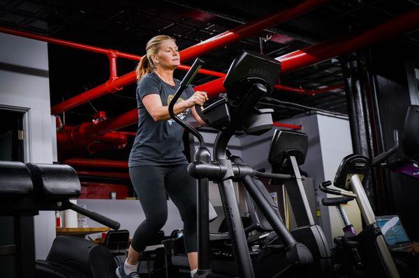 Client warming up for their session on the elliptical machine