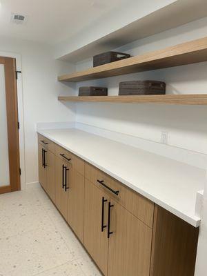 Folding space in the laundry area with custom shelving units and cabinetry.