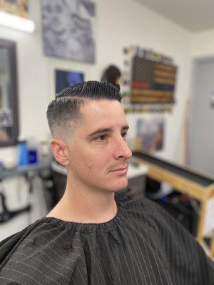 Skin fade, parted haircut with the hard line.