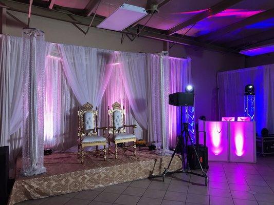 Engagement party stage set up. Backdrop + chairs and lighting