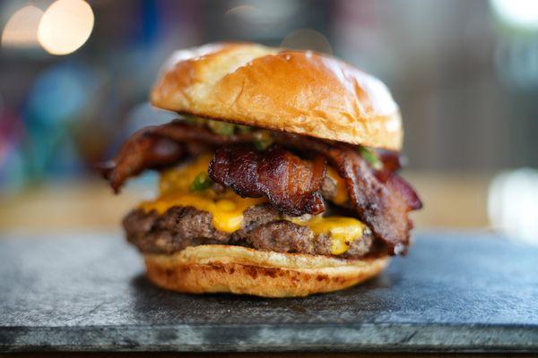 100% Beef Hand-Rolled Daily, Melted Cheese, Special Sauce, Relish, Onion, and Tomato served on a Buttered Bun with Kettle Chips.